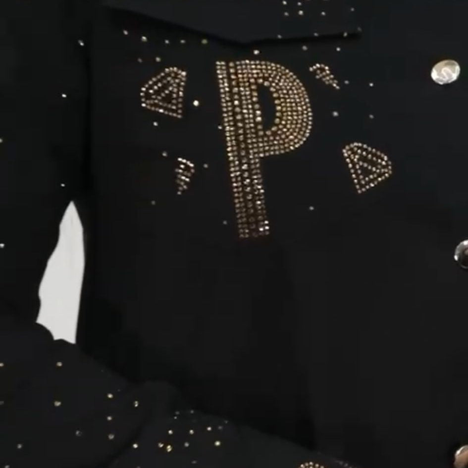 0023 PAPARAZZI Robe a volants col chemise boutonnée jusqu’à la taille des strass dorés un peu partout ainsi que sur les logos de la marque ceinture fournie