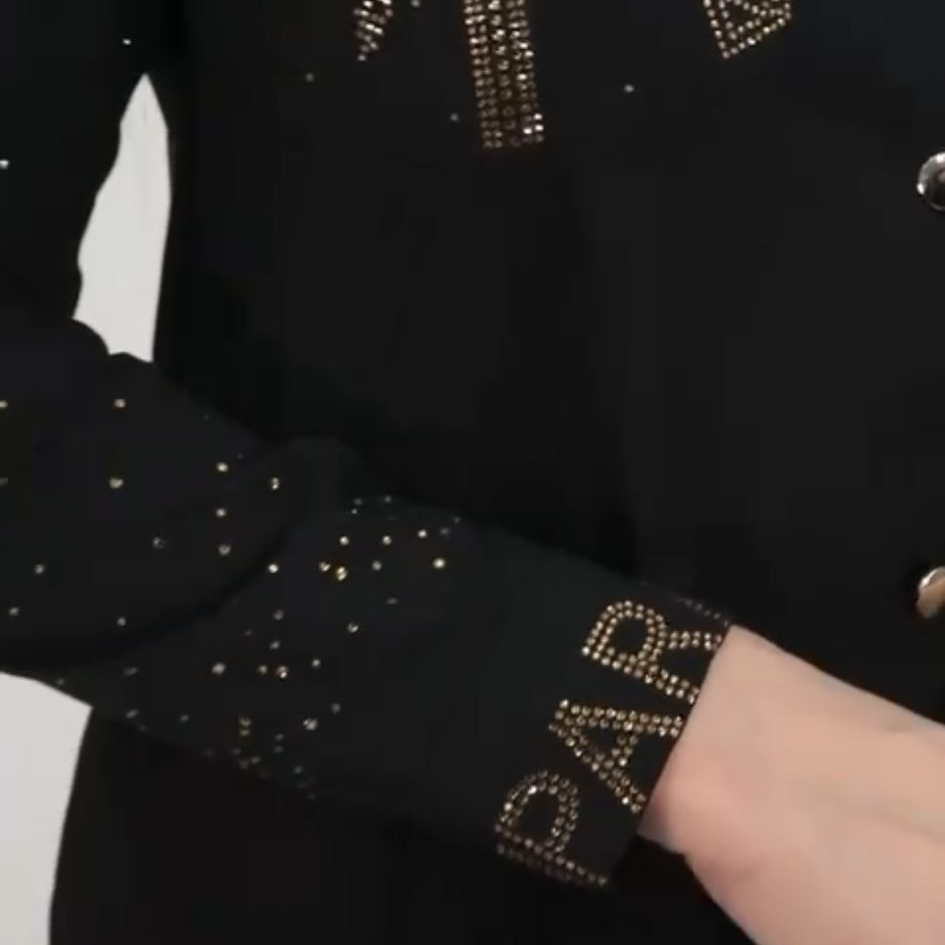 0023 PAPARAZZI Robe a volants col chemise boutonnée jusqu’à la taille des strass dorés un peu partout ainsi que sur les logos de la marque ceinture fournie