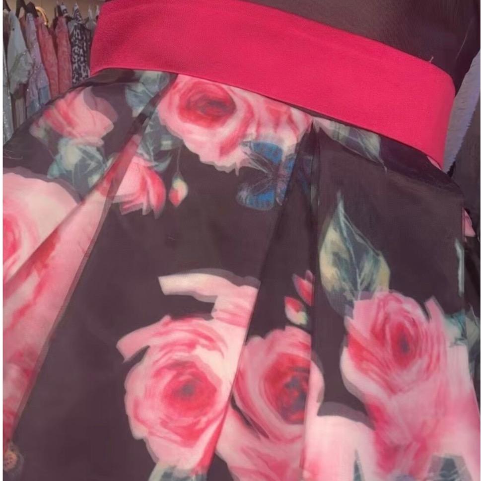 ROBE PATINEUSE ÉLÉGANTE en tissu brillant avec haut noir décolleté en V et jupe motifs roses fuchsia pour occasions spéciales