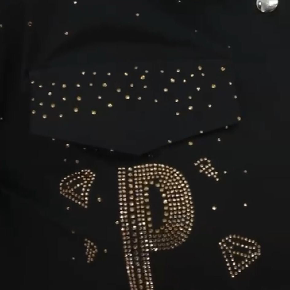 0023 PAPARAZZI Robe a volants col chemise boutonnée jusqu’à la taille des strass dorés un peu partout ainsi que sur les logos de la marque ceinture fournie