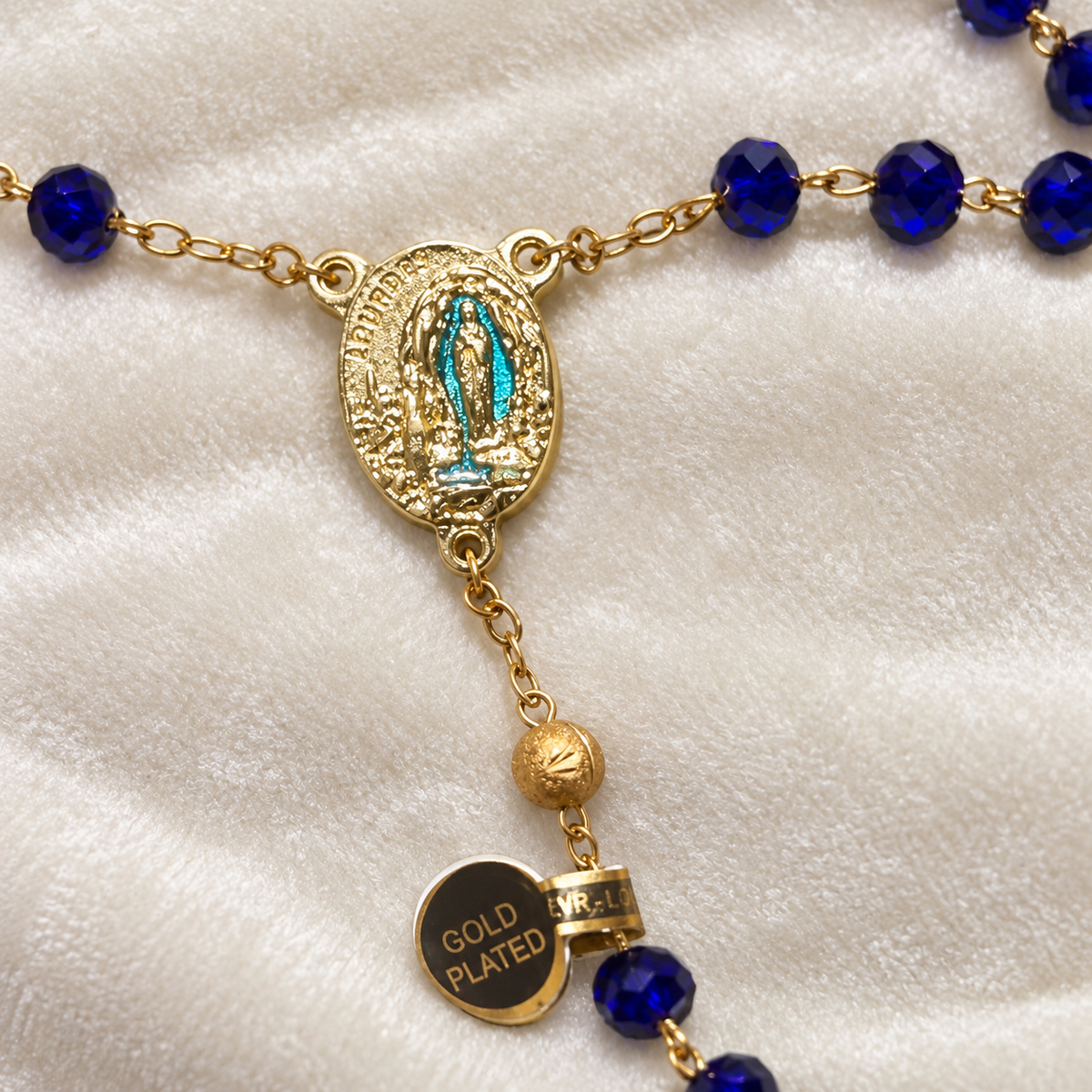 Détail de la médaille de Notre-Dame de Lourdes et des perles bleu nuit