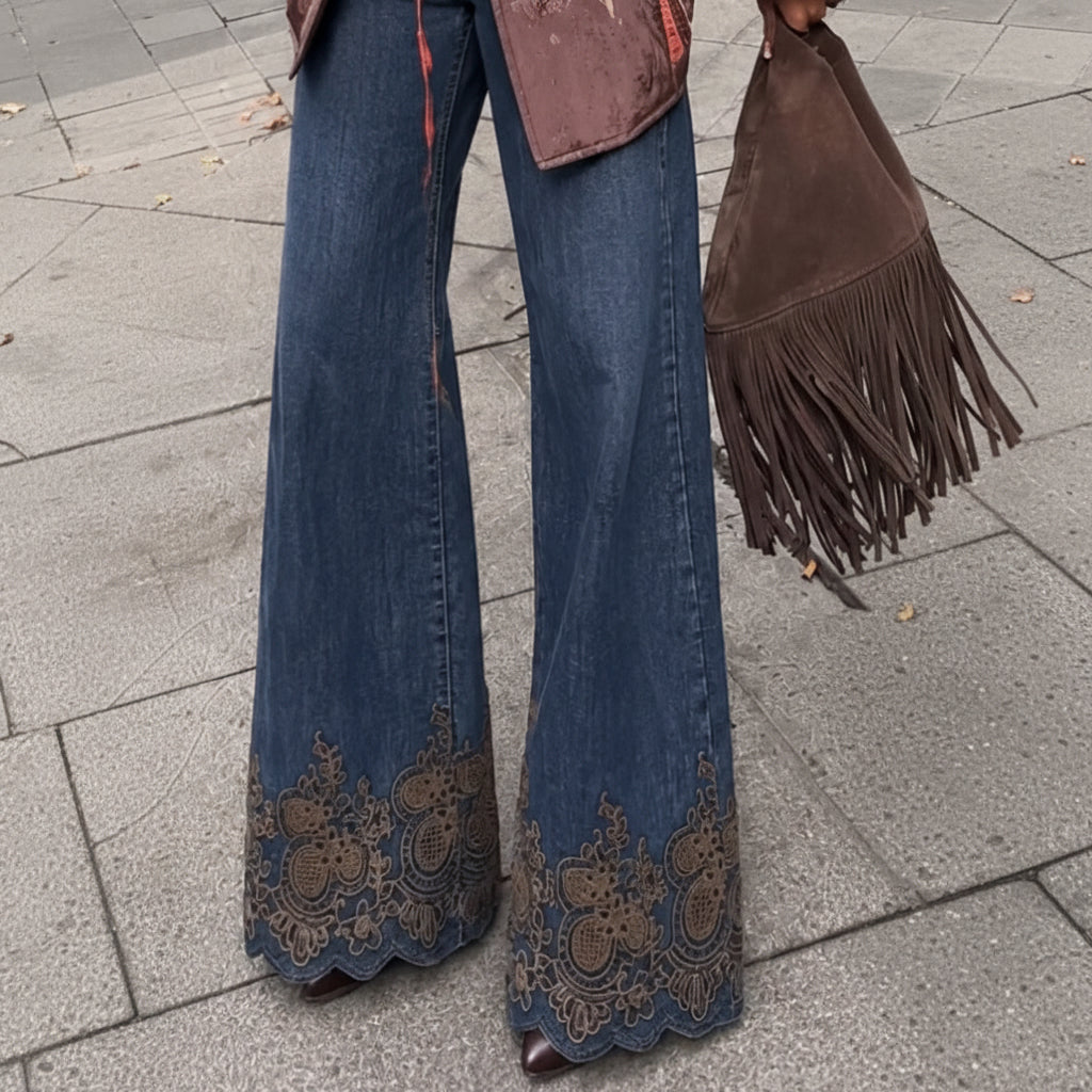 Jean brodé B6213 – jean femme bleu foncé en denim brut, coupe large taille haute et broderies florales dorées au bas des jambes, détails festonnés pour une silhouette bohème chic originale