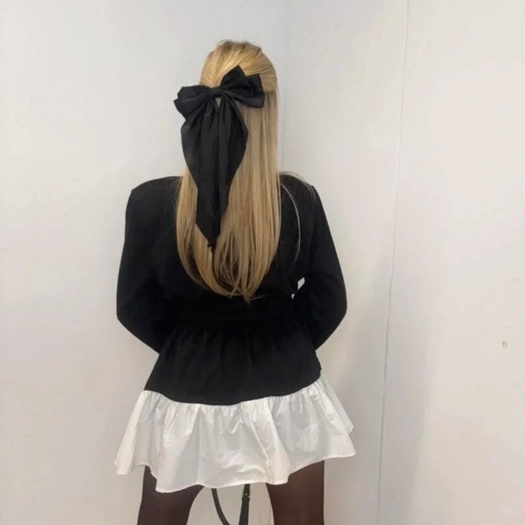 PAPARAZZI 3324  Robe, chemise de luxe avec un col et une jupette évasée en tissu blanc. Tout le buste est noir avec des logos en strass dorés et une ceinture élastique.