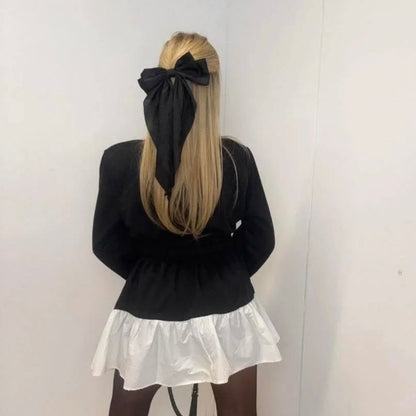 PAPARAZZI 3324  Robe, chemise de luxe avec un col et une jupette évasée en tissu blanc. Tout le buste est noir avec des logos en strass dorés et une ceinture élastique.