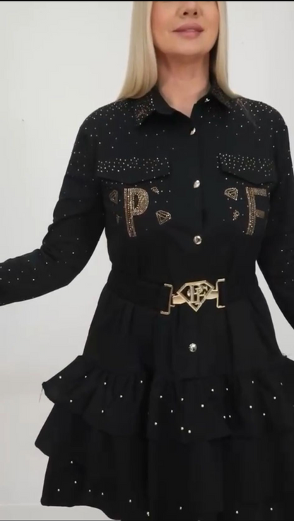 0023 PAPARAZZI Robe a volants col chemise boutonnée jusqu’à la taille des strass dorés un peu partout ainsi que sur les logos de la marque ceinture fournie