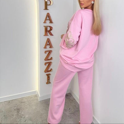 PAPARAZZI 1201 Ensemble jogging rose bonbon, Taille UNIQUE, over size très confortable au touché très doux,, sweat long à logo strass brillant et pantalon large assorti, tenue loungewear chic avec détails dorés sur les manches pour un look détente premium