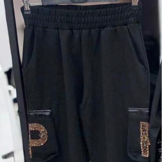 Paparazzi Fashion 3639 Ensemble sport chic sweat et pantalon femme noirs à détails de strass dorés, tenue coordonnée confortable au style urbain chic, à porter avec des baskets pour une allure moderne chic.