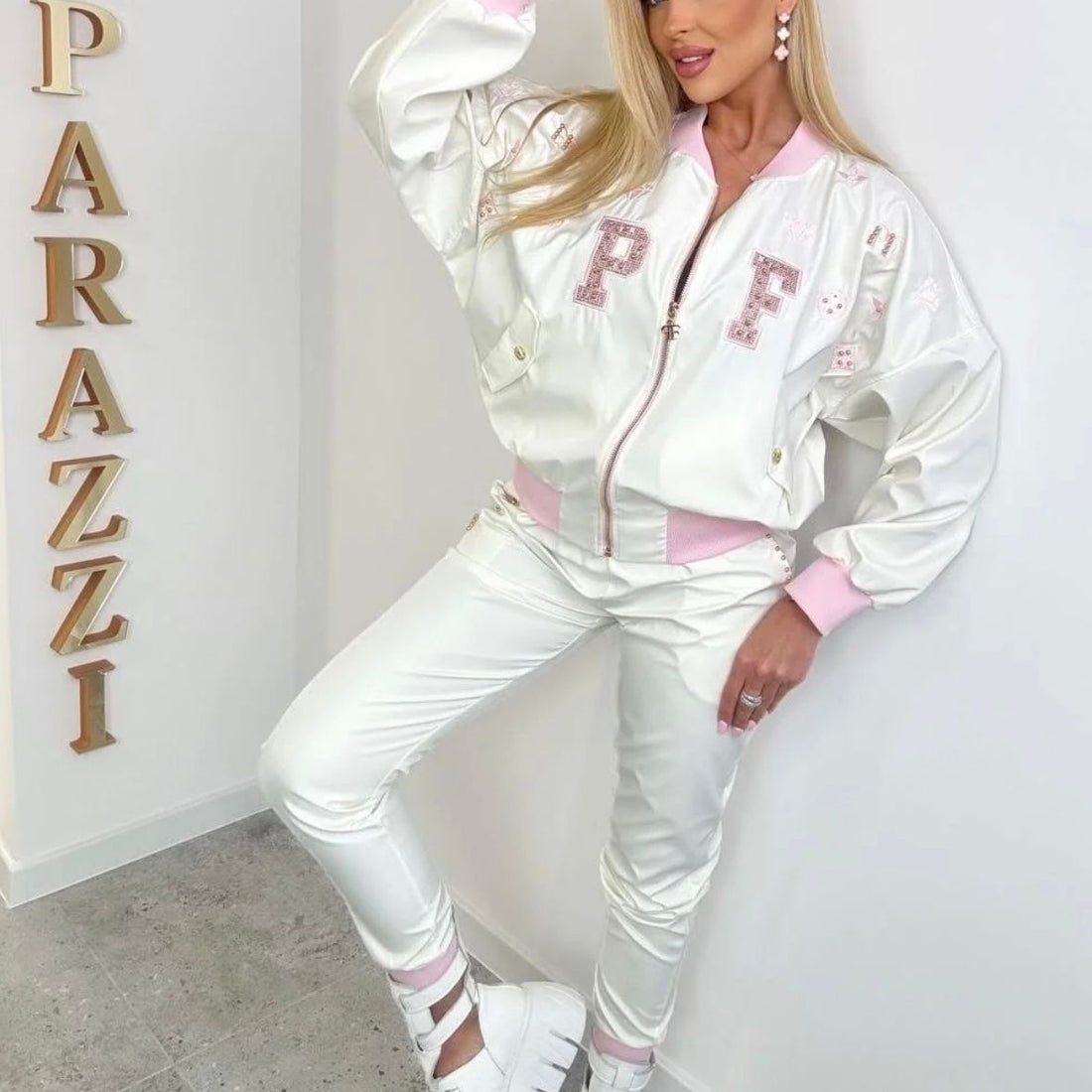 0093 PAPARAZZI ensemble de survêtement ultra-chic en satin blanc nacré et finitions rose bonbon - veste bomber à logo pailleté et pantalon slim assorti pour un look streetwear glamour et audacieux au quotidien.