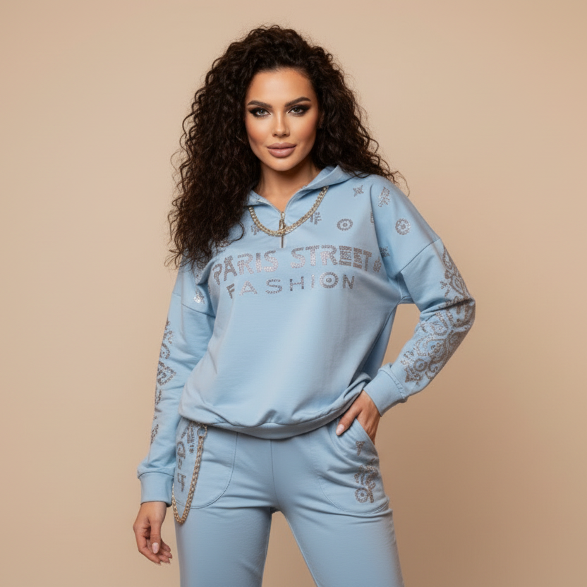 Jogging bijou 0081 – Paparazzi Fashion ensemble femme deux pièces en bleu ciel ou blanc selon disponibilité, haut zippé à capuche, chaîne dorée et logo strassé, style urbain chic et lumineux