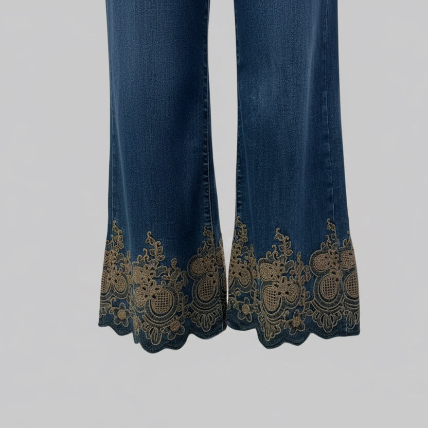 Jean brodé B6213 – jean femme bleu foncé en denim brut, coupe large taille haute et broderies florales dorées au bas des jambes, détails festonnés pour une silhouette bohème chic originale