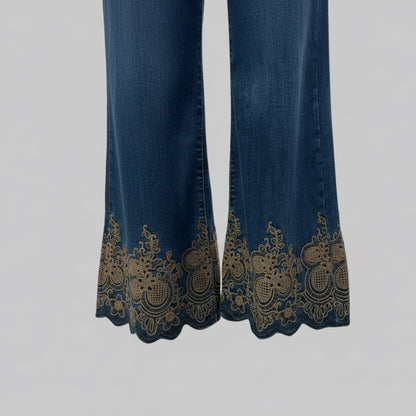 Jean brodé B6213 – jean femme bleu foncé en denim brut, coupe large taille haute et broderies florales dorées au bas des jambes, détails festonnés pour une silhouette bohème chic originale