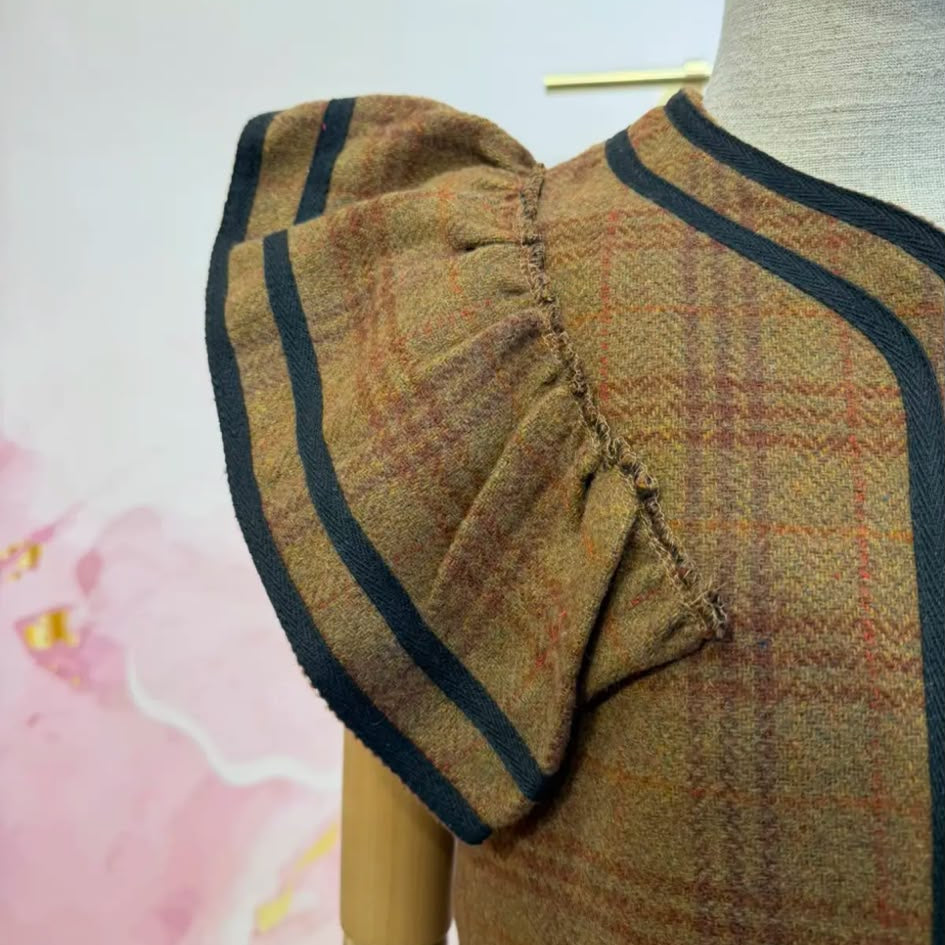 Gilet volanté 82162 – gilet sans manches gris à carreaux avec volants plissés aux épaules et bordures noires contrastées, coupe ouverte pour superposer sur une blouse ou un haut uni