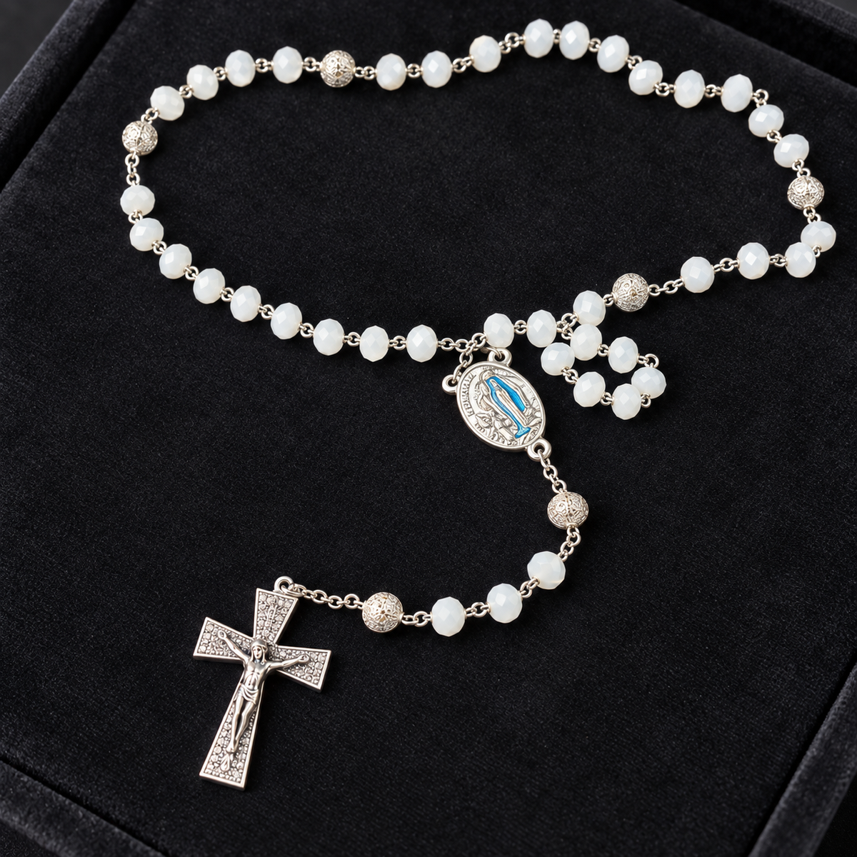 Croix argentée, médaille et perles blanches facettées du chapelet de Lourdes