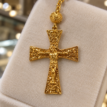 Détail de la croix en plaqué or du chapelet de Lourdes sur un présentoir de bijouterie