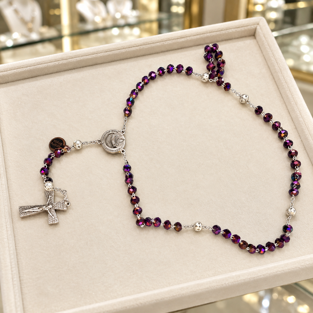 Chapelet de Lourdes en cristal violet irisé et plaqué argent présenté en bijouterie
