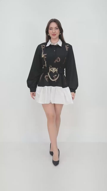 PAPARAZZI 3324  Robe, chemise de luxe avec un col et une jupette évasée en tissu blanc. Tout le buste est noir avec des logos en strass dorés et une ceinture élastique.